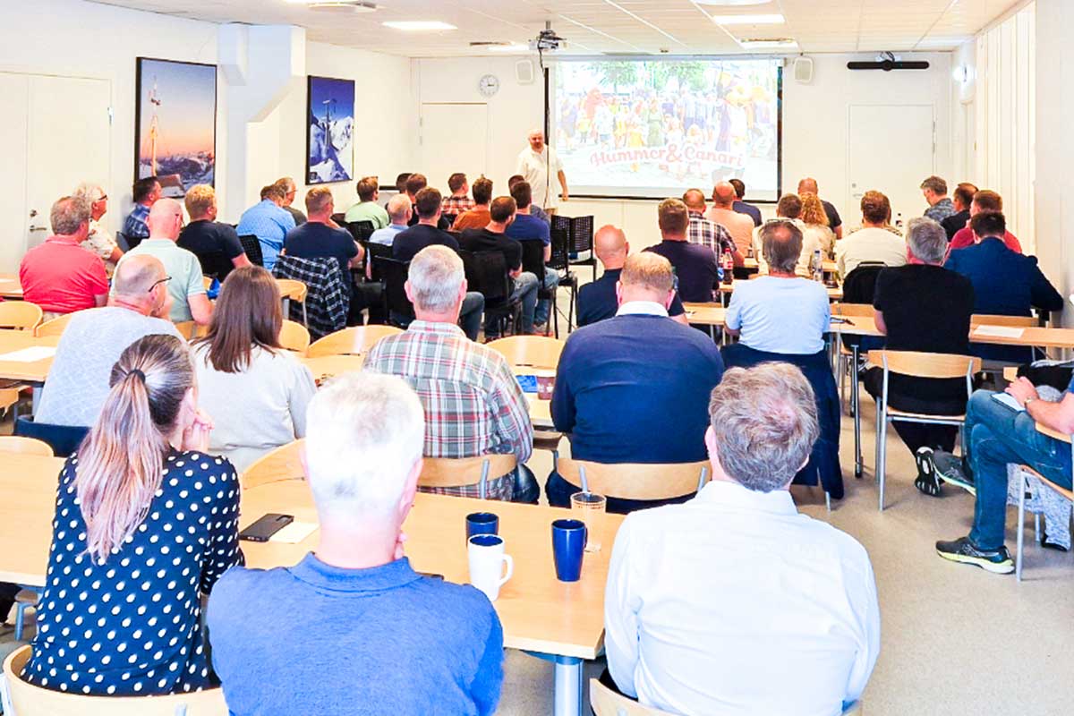 Møte i konferanserom med presentasjon på storskjerm.